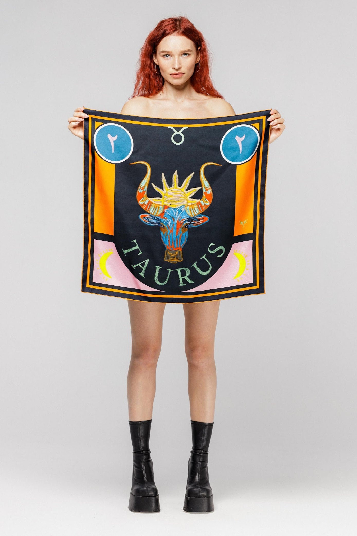 Model holding silk twill square scarf with Taurus design