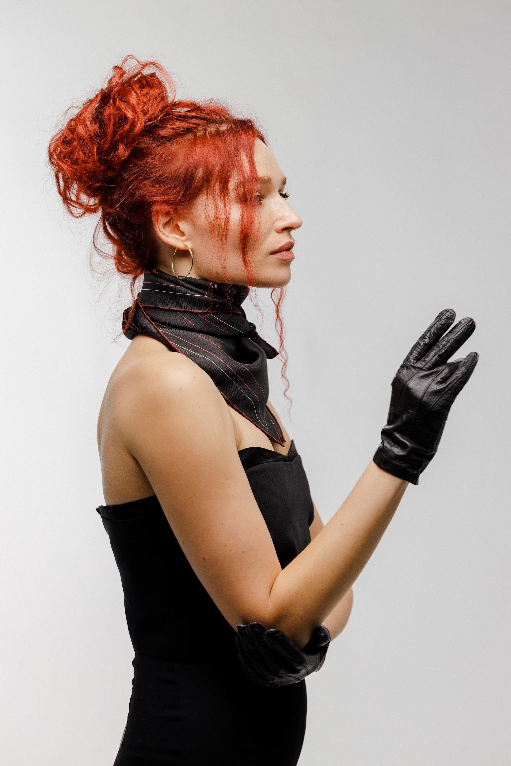 Model wearing black silk twill square scarf around neck