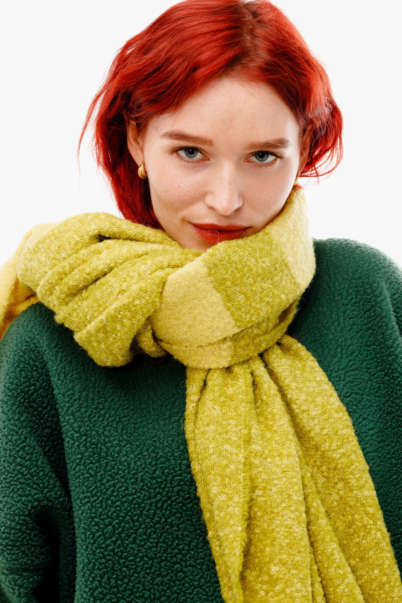 Model wearing alpaca wool scarf around neck with yellow and green design