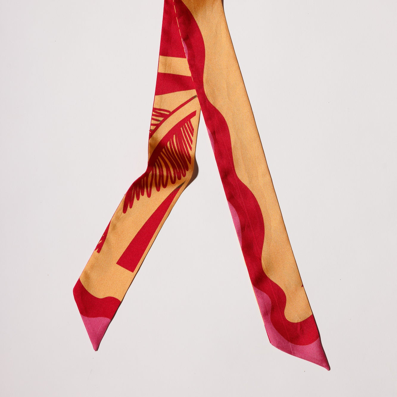 Silk twilly scarf in orange and pink print with point angles