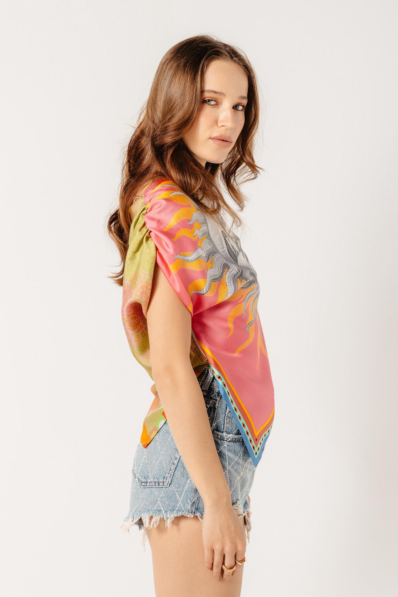 Model wearing asymmetrical top with pink front and green back in silk