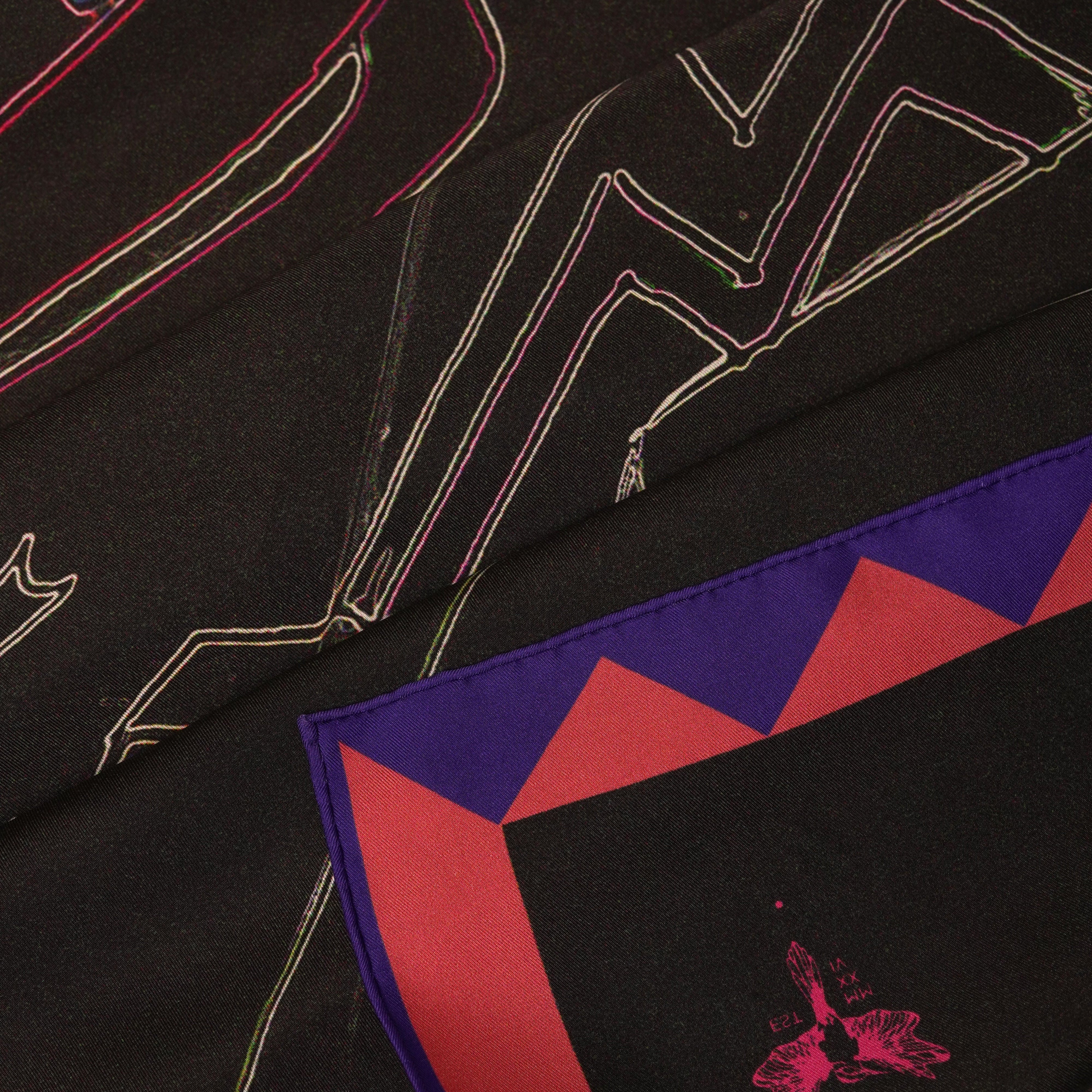 Close-up on silk twill scarf with black pink and blue design