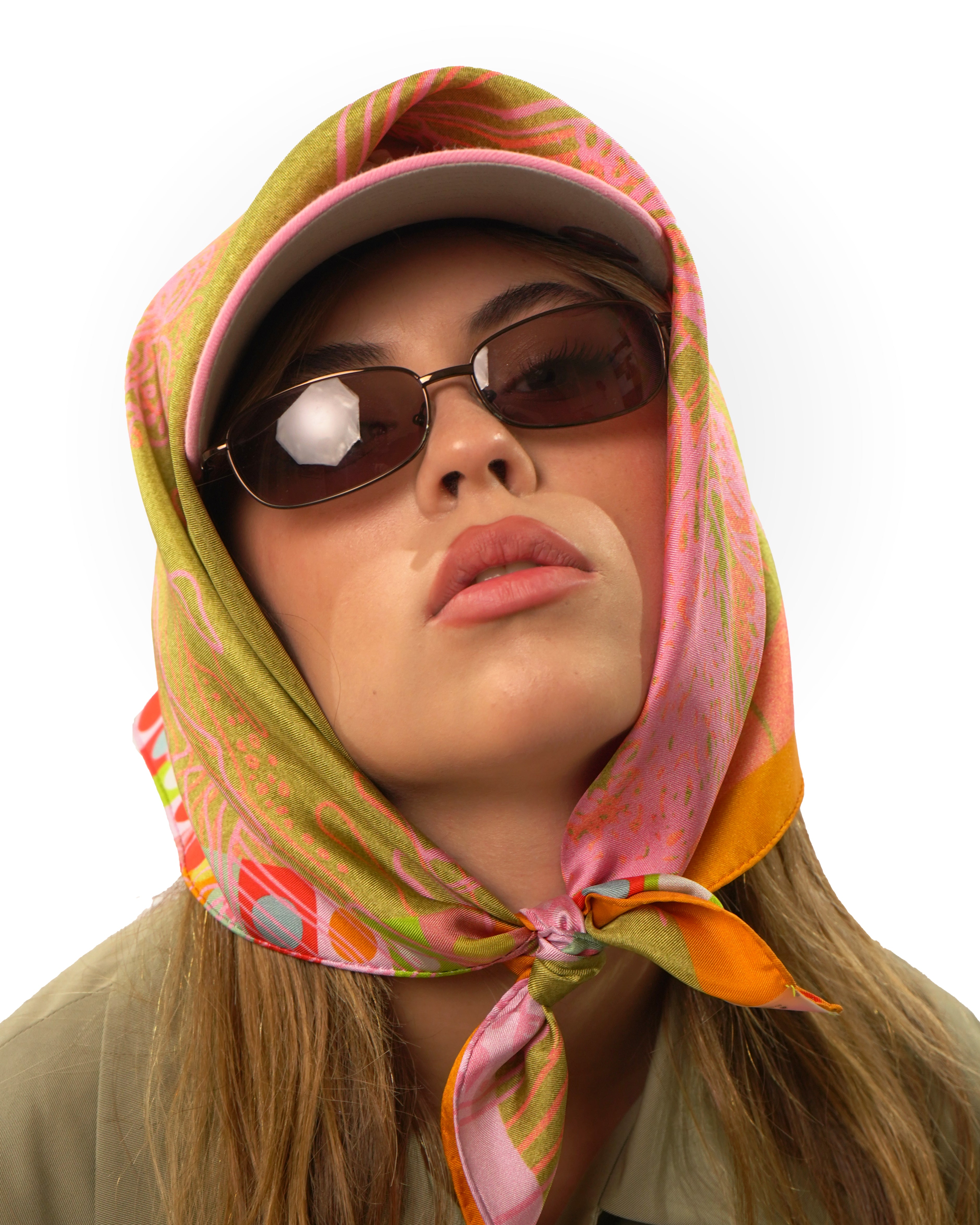 Model wearing silk square scarf around cap on her head