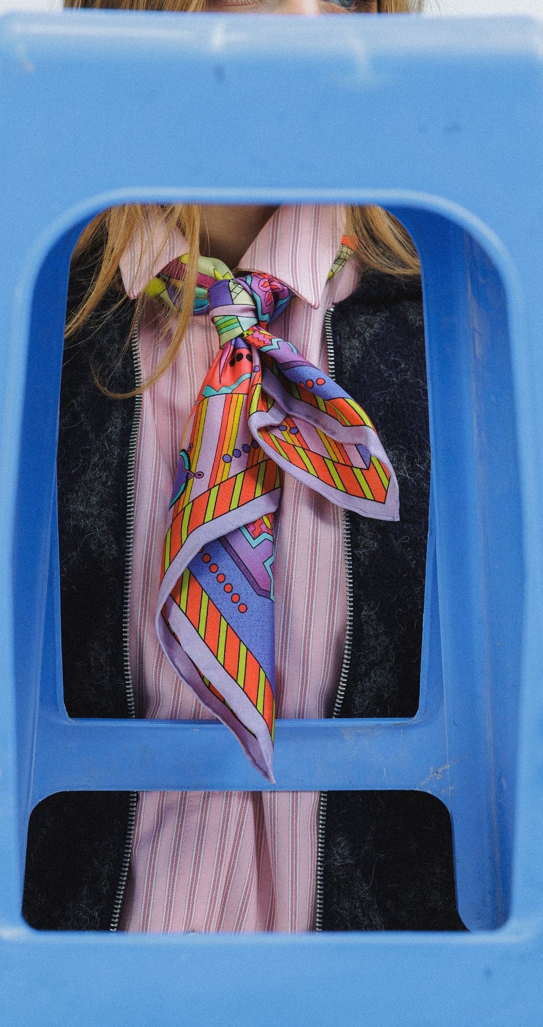 Model wearing colorful silk scarf as a tie around her neck
