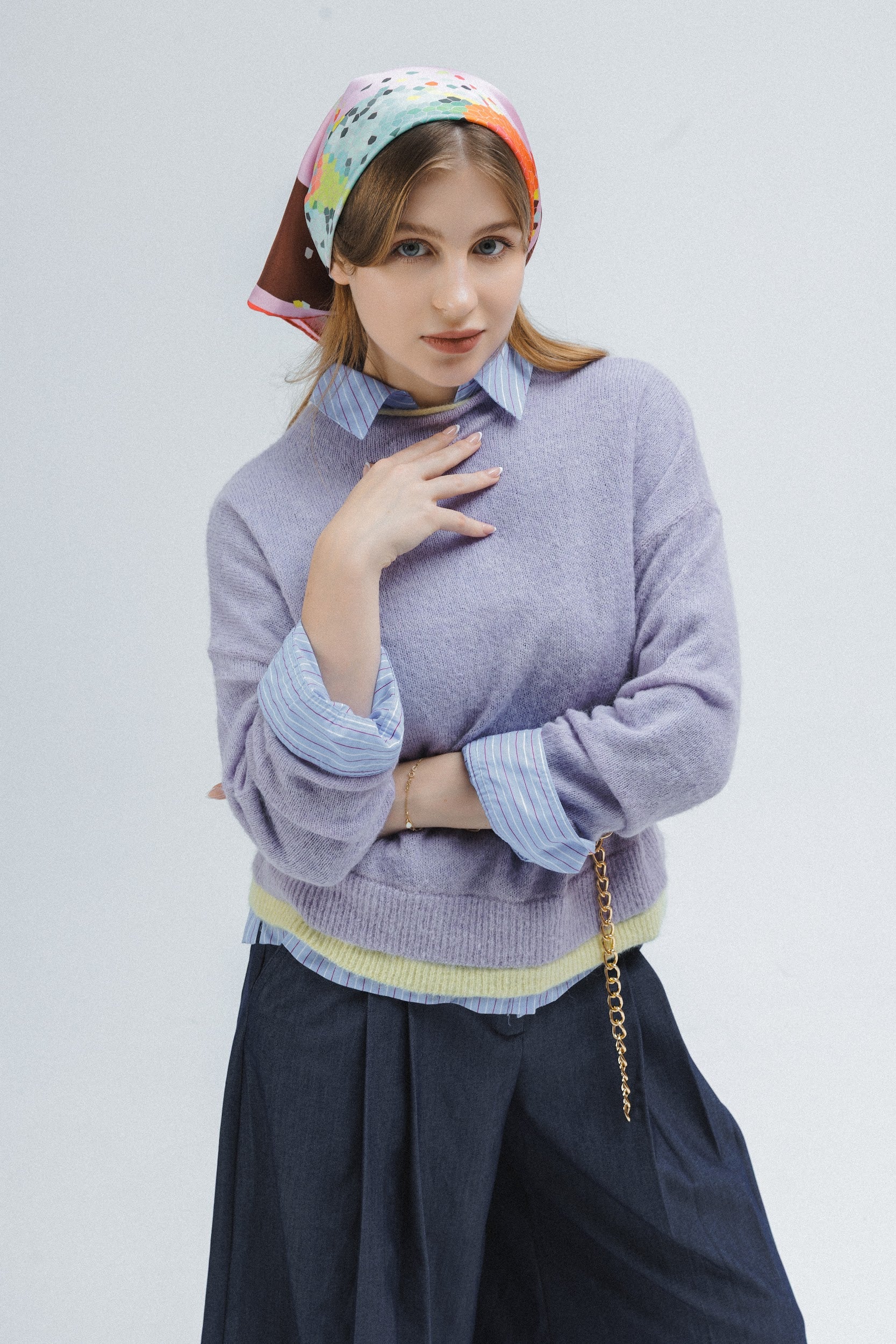 Model wearing a silk scarf with abstract design styled as a bandana on her hair