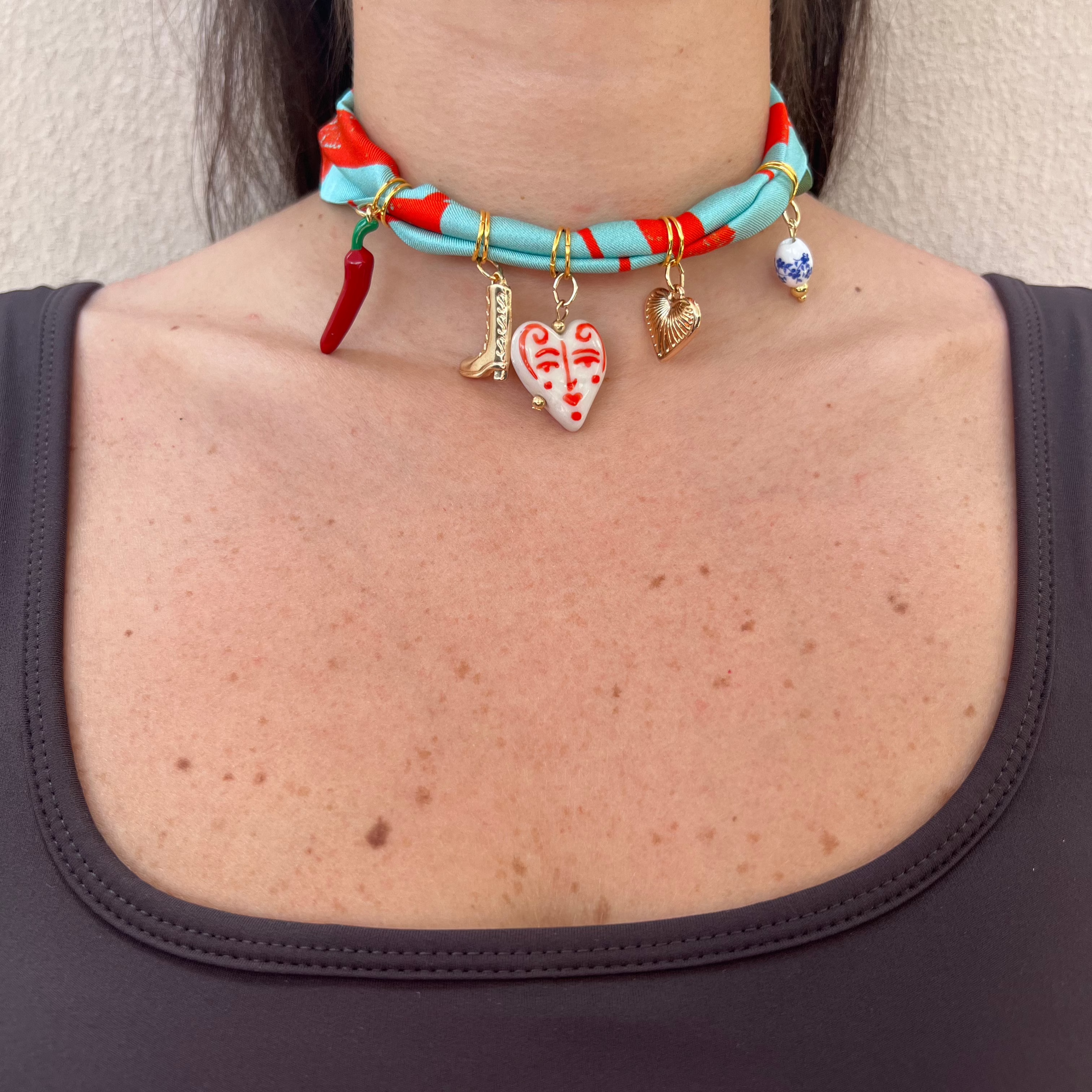 charm necklace with five charms on silk twill fabric
