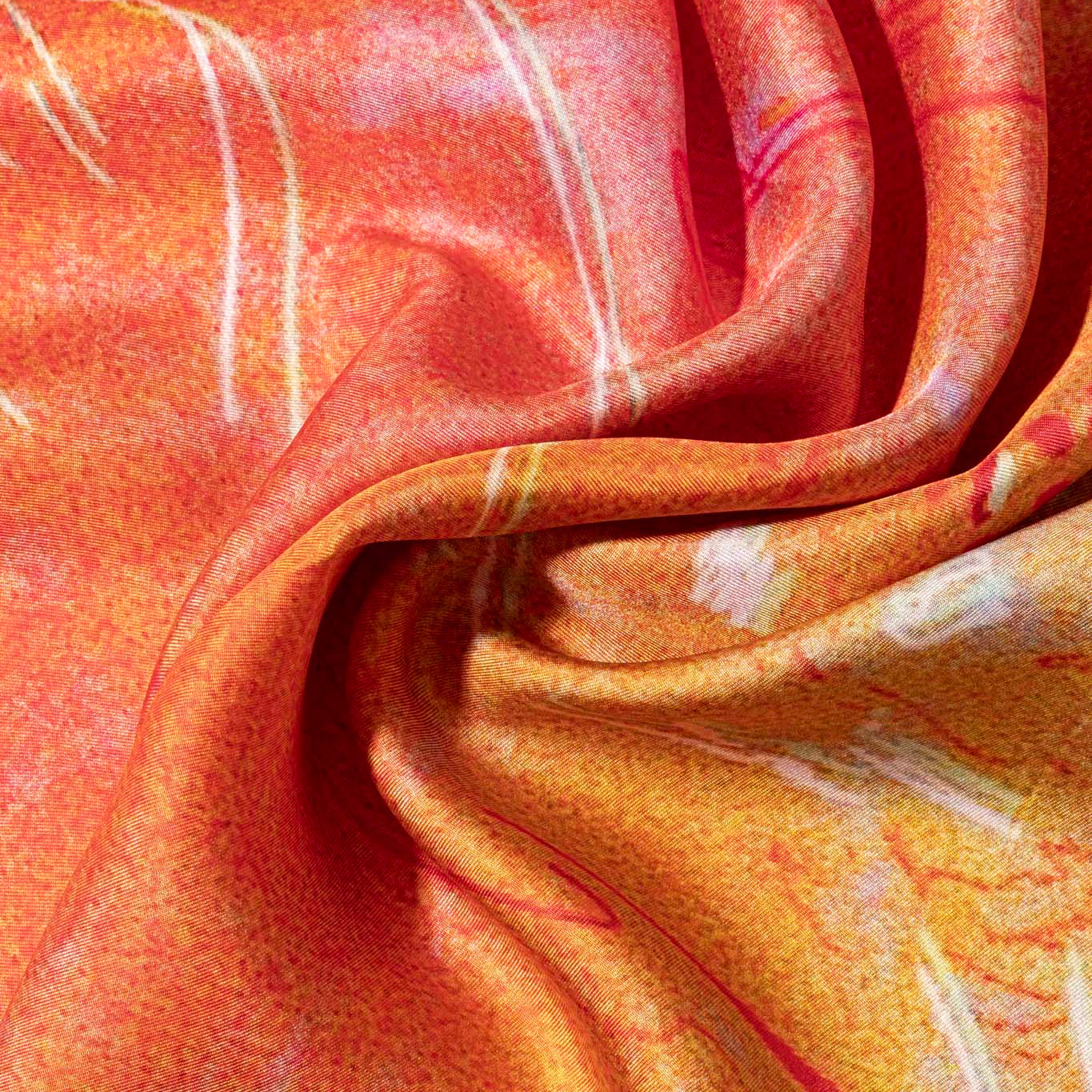 Close-up of orange silk scarf with abstract patterns