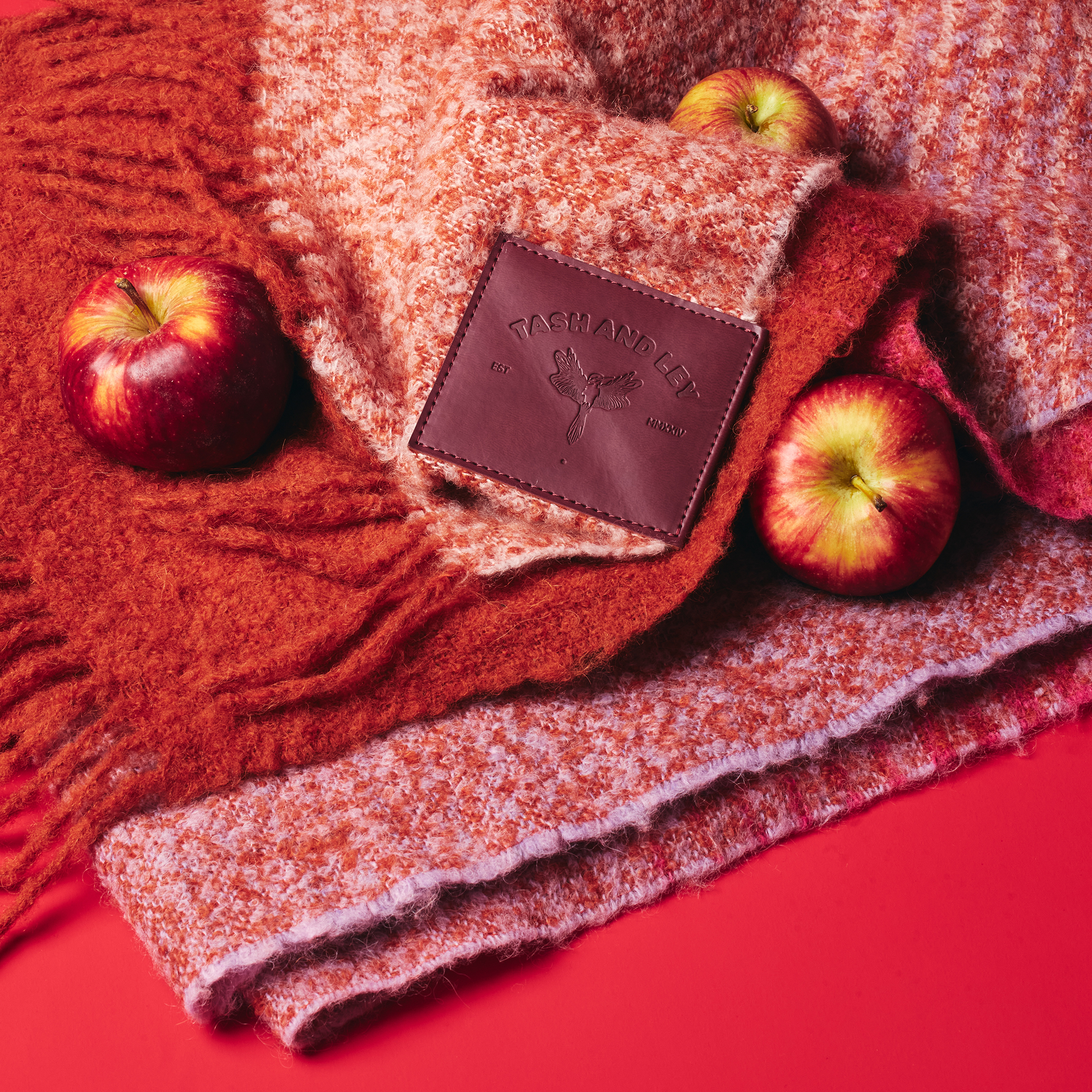 Pink purple and orange alpaca wool scarf with apples on a red background