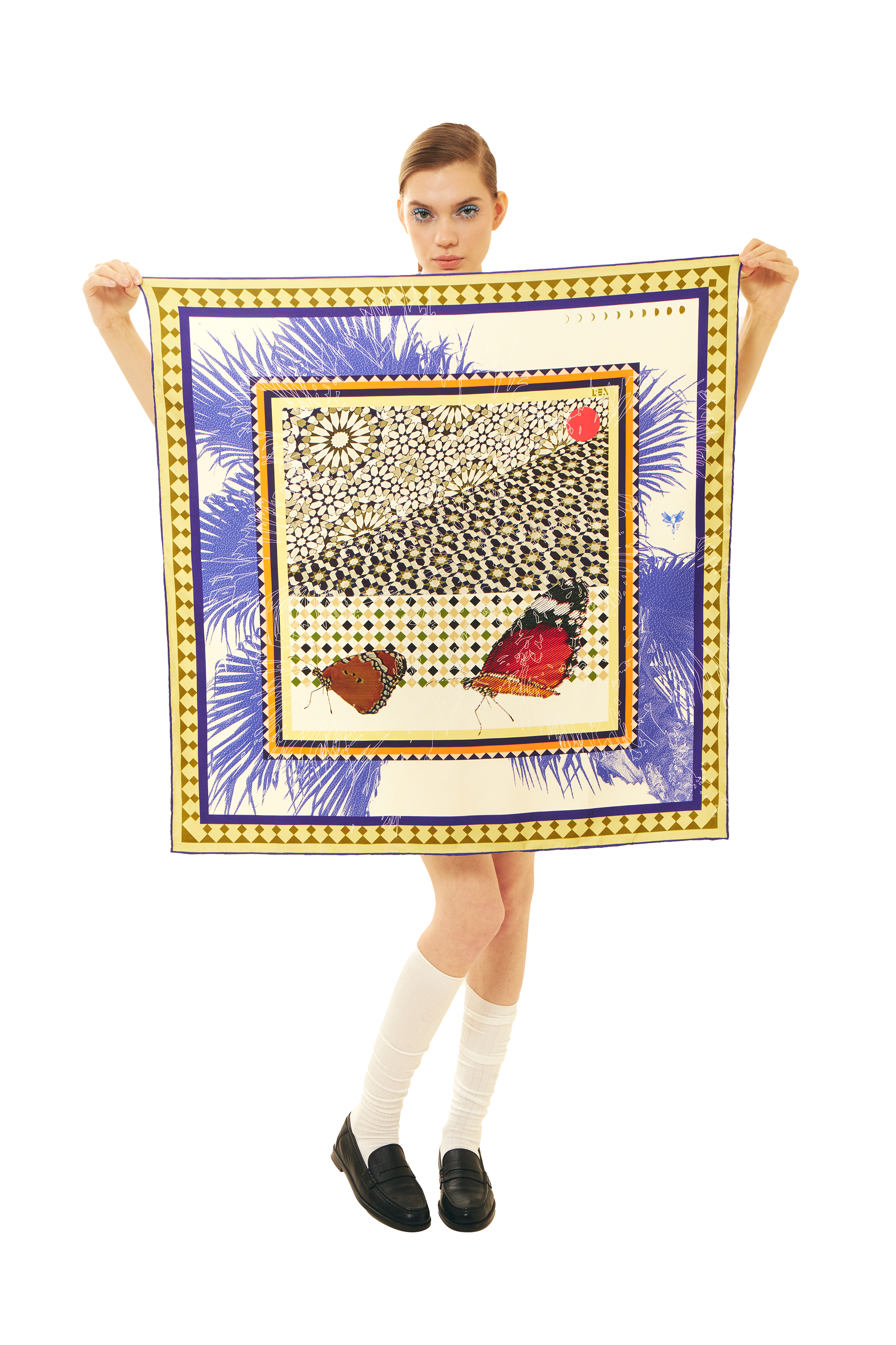 Person holding a square silk scarf with a colorful design on a white background