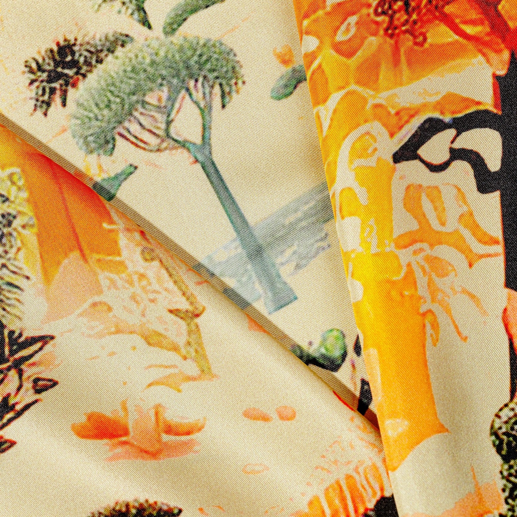 Close-up of a silk twill scarf a nature-themed print featuring trees and plants.