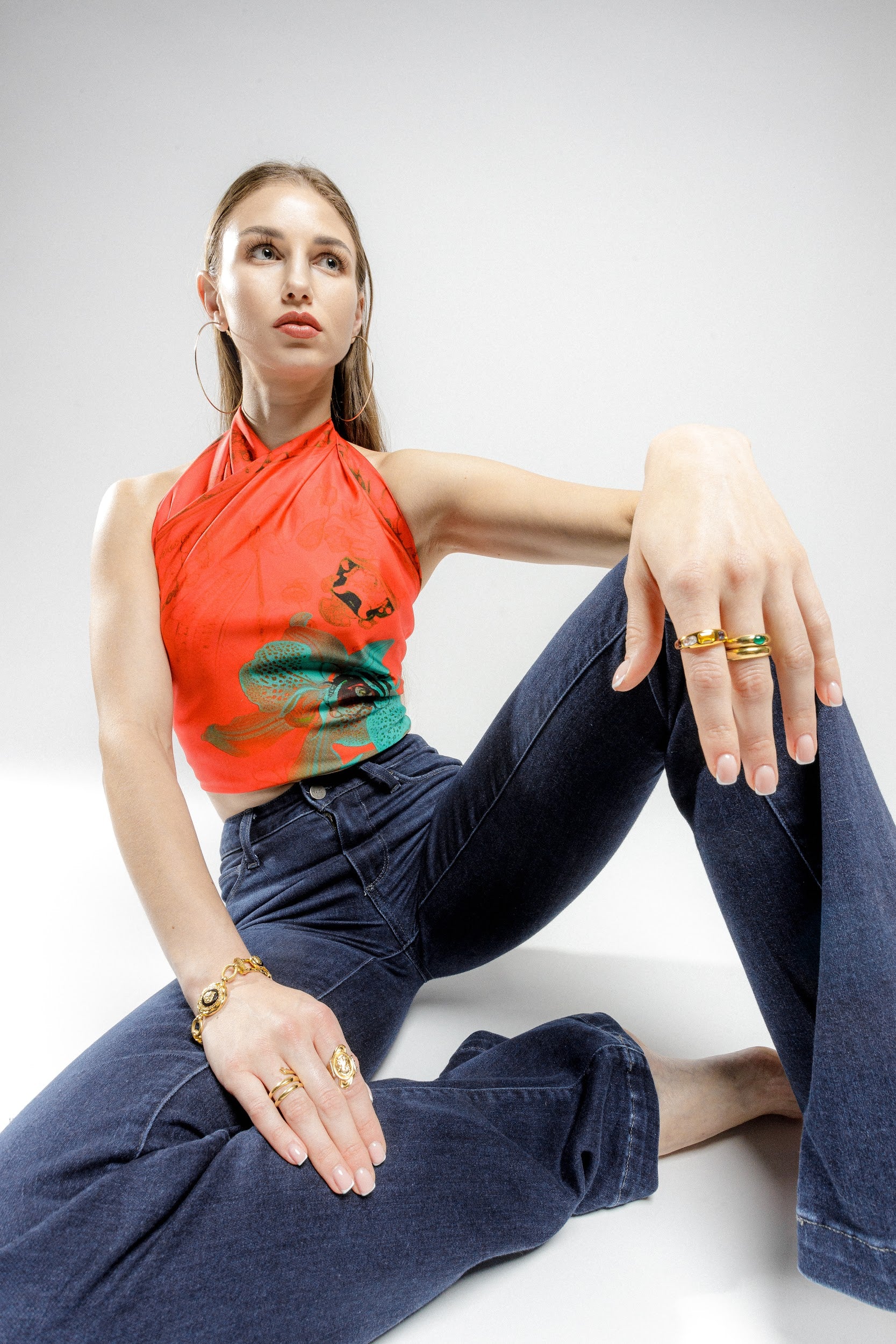 Model wearing silk twill square scarf with orange and turquoise print as a top