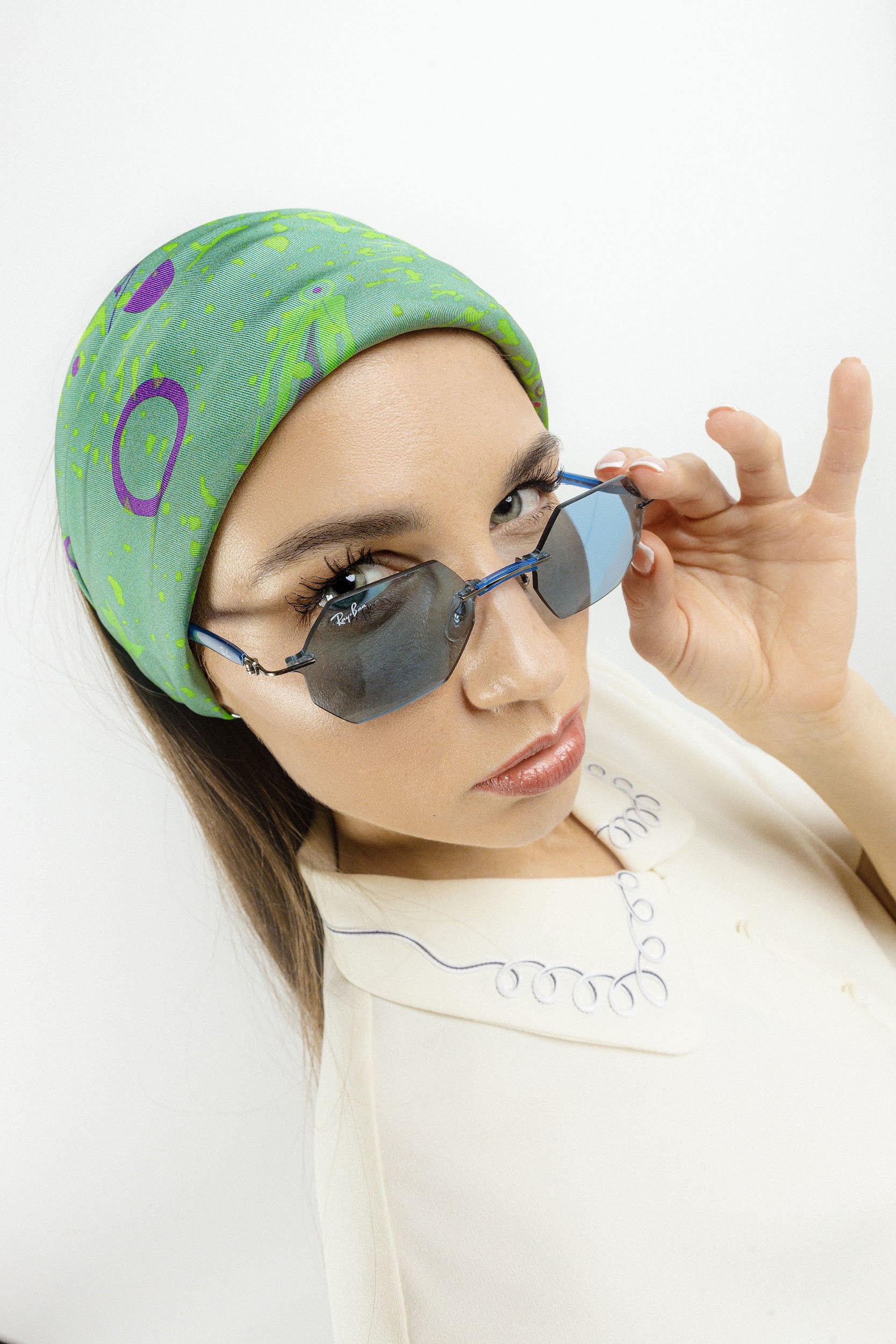 Model wearing silk twill square scarf with green print as a headband