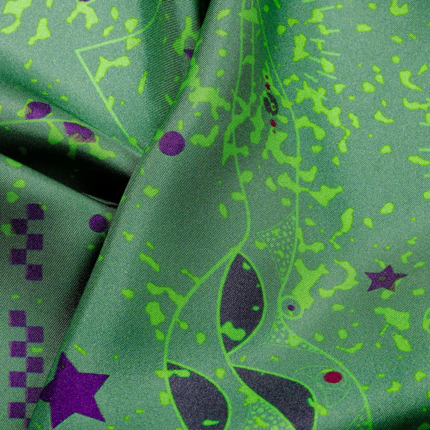 zoom on silk twill fabric with drawing details in green and purple