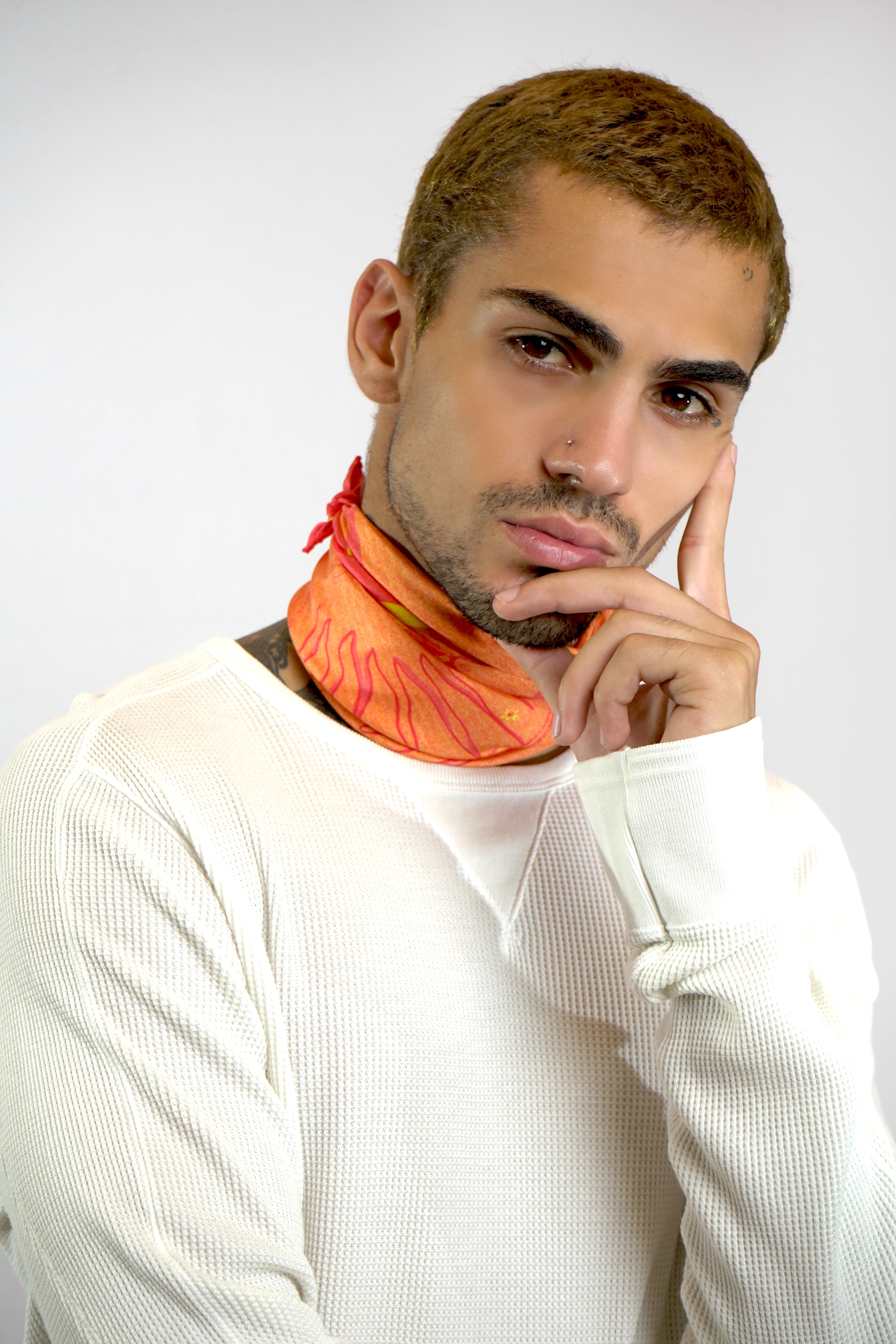 Male model wearing pink silk twill square scarf around neck