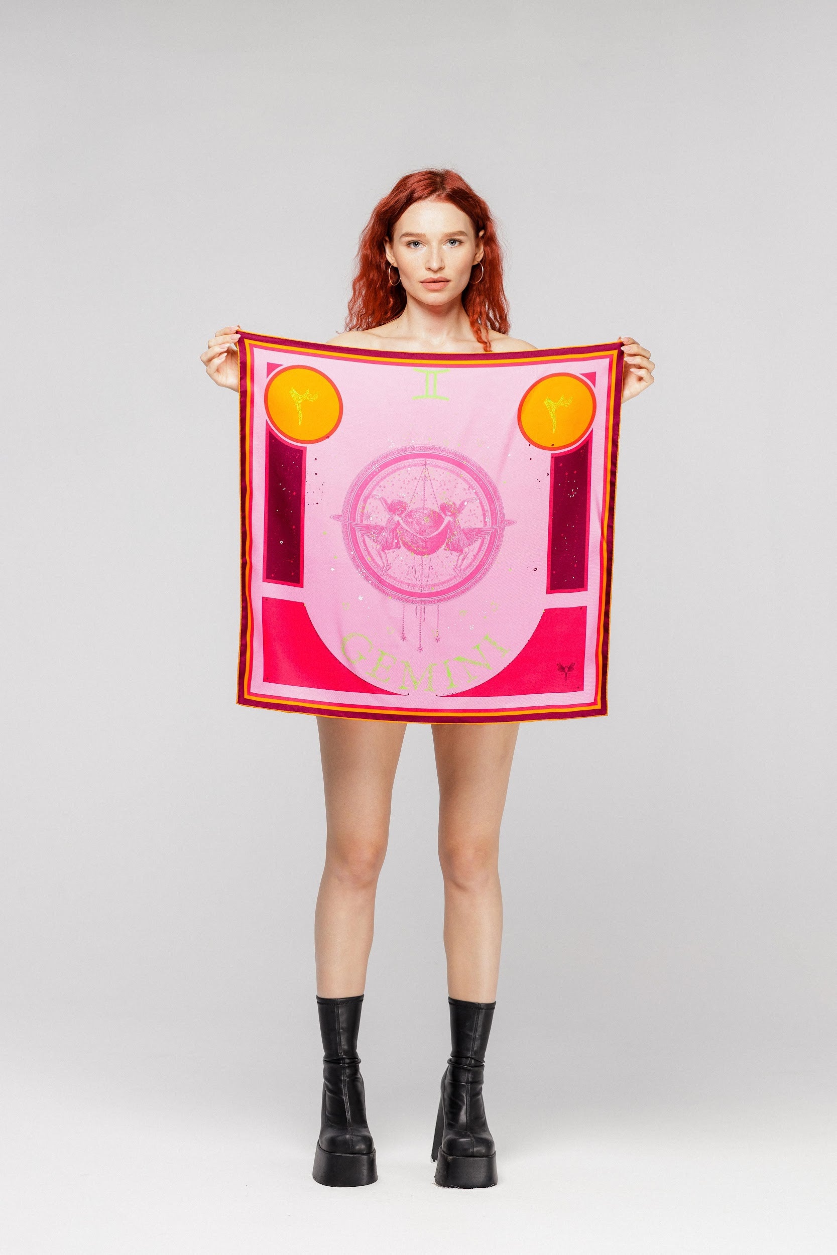 Model holding silk twill square scarf with gemini design