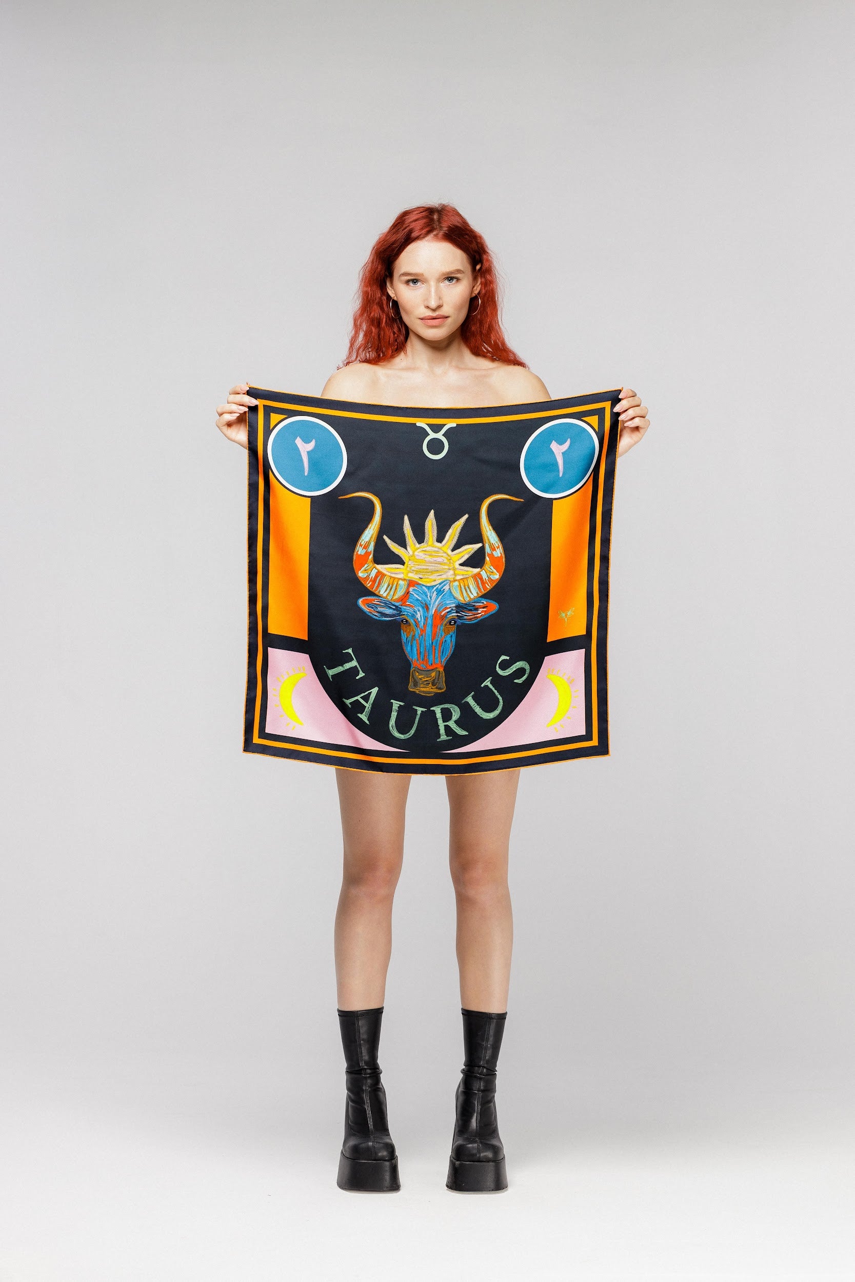 Model holding silk twill square scarf with Taurus design