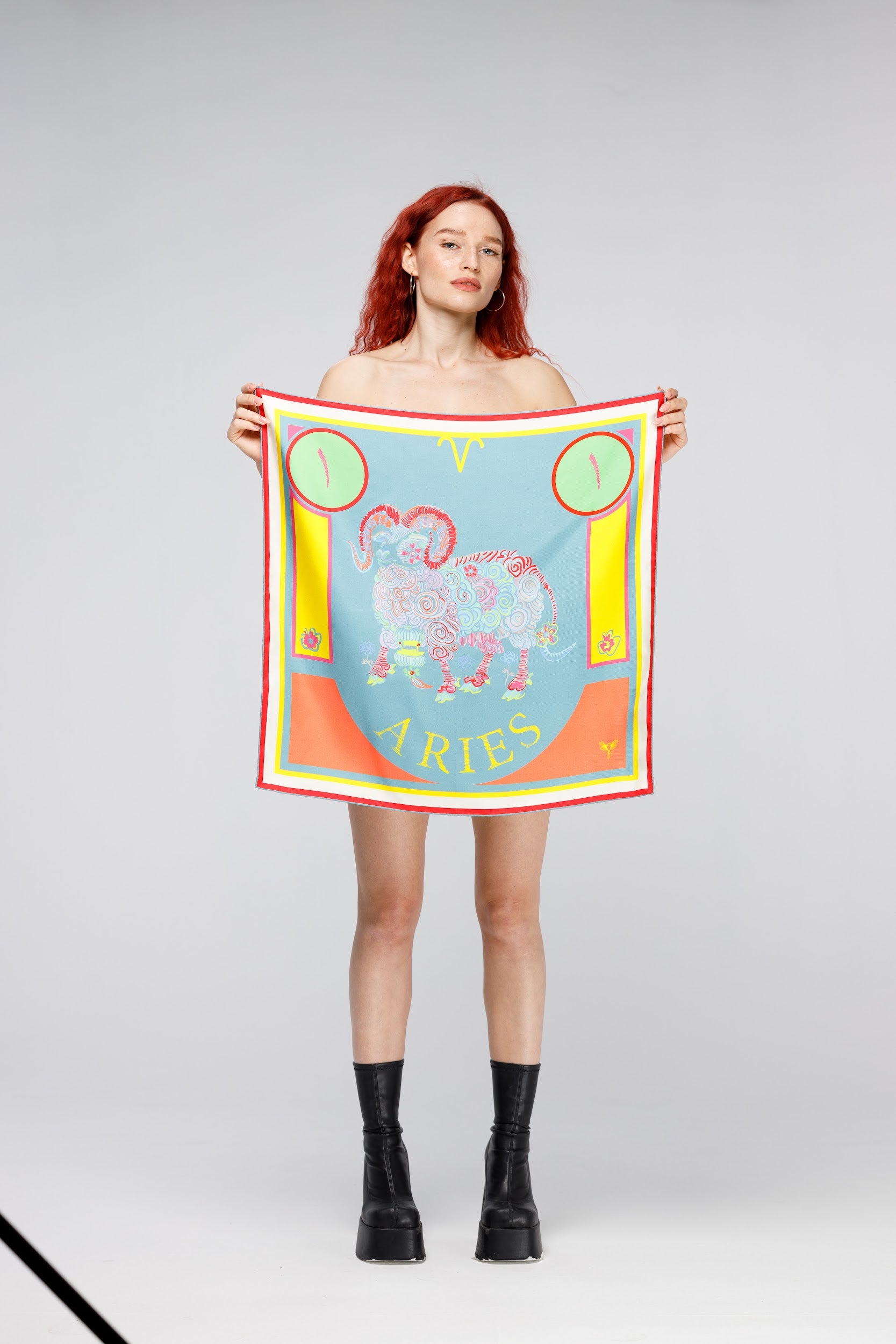 Model holding silk twill square scarf with Aries design Astrology