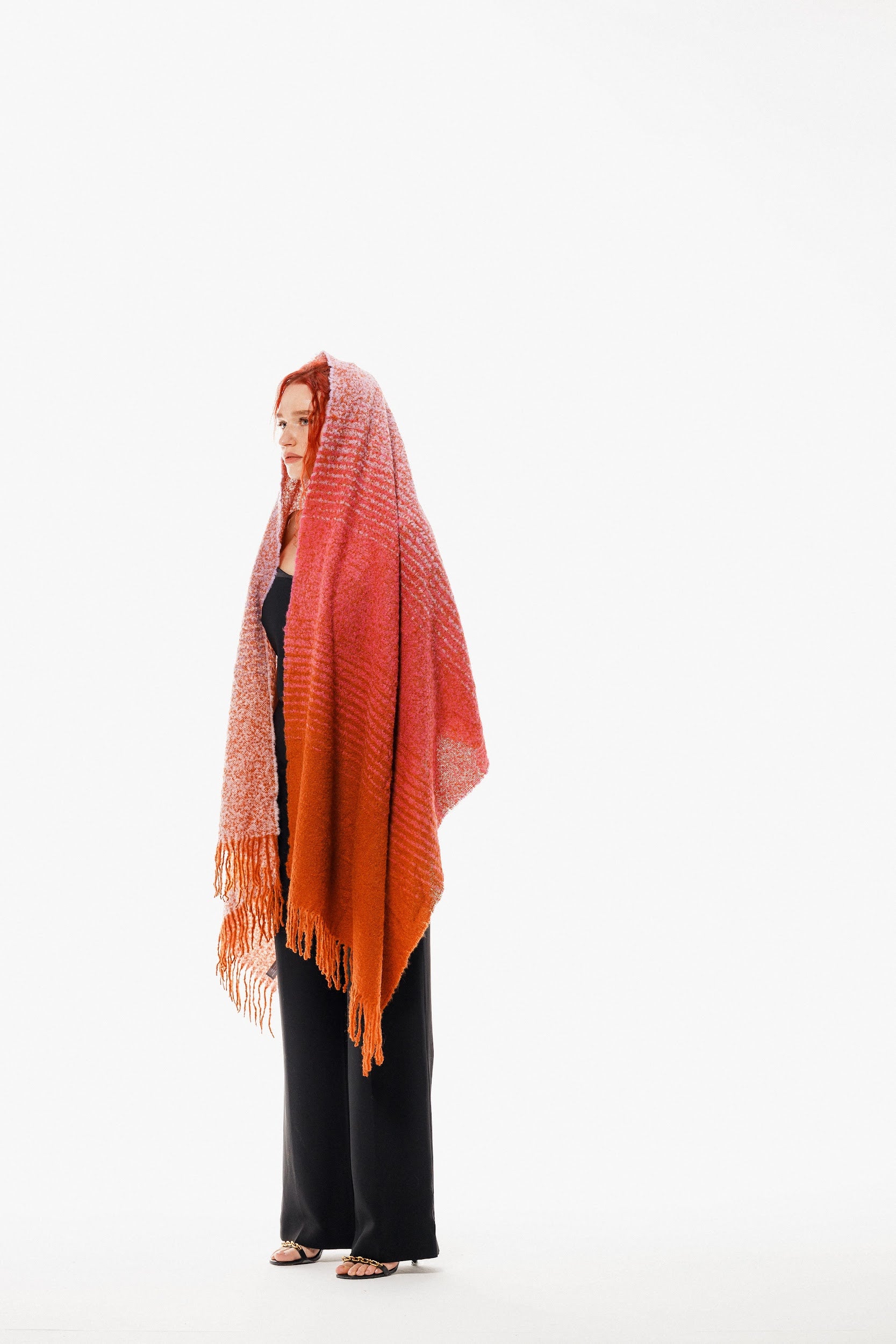 Model wearing a long winter scarf made in alpaca wool with pink orange lilac colors