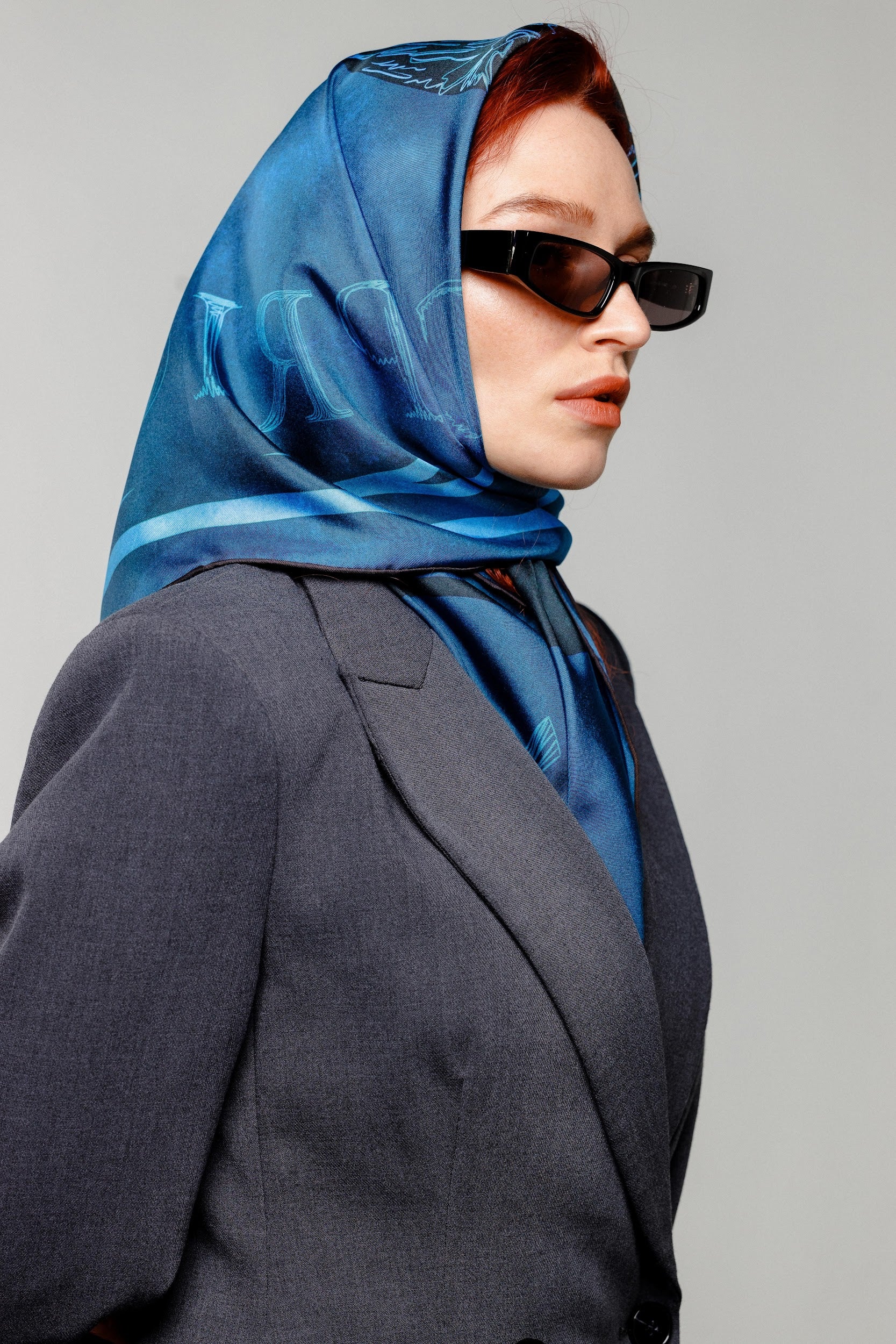 Model wearing blue Capricorn design silk twill square scarf as head wrap