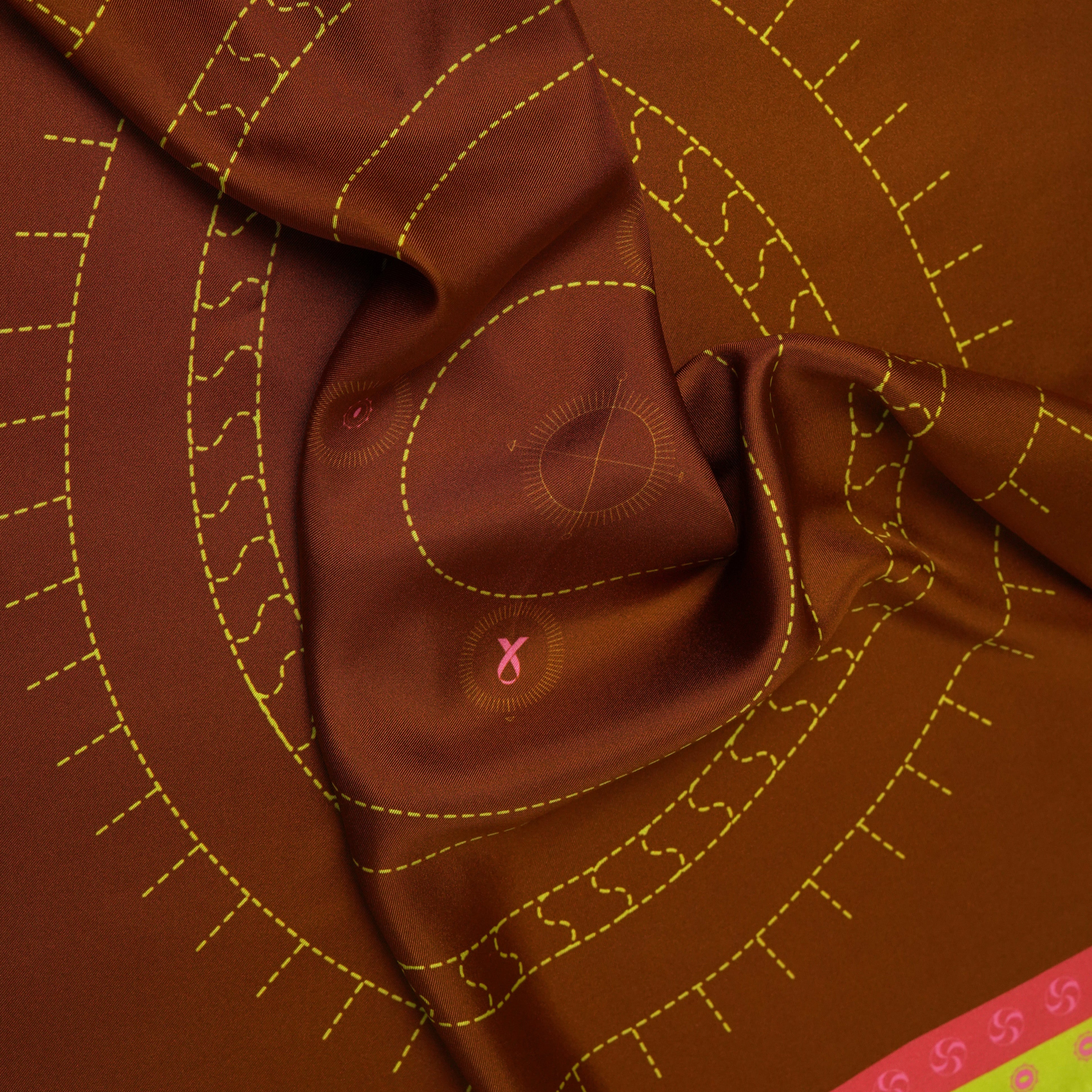 Close-up of brown silk scarf with green and pink geometric pattern