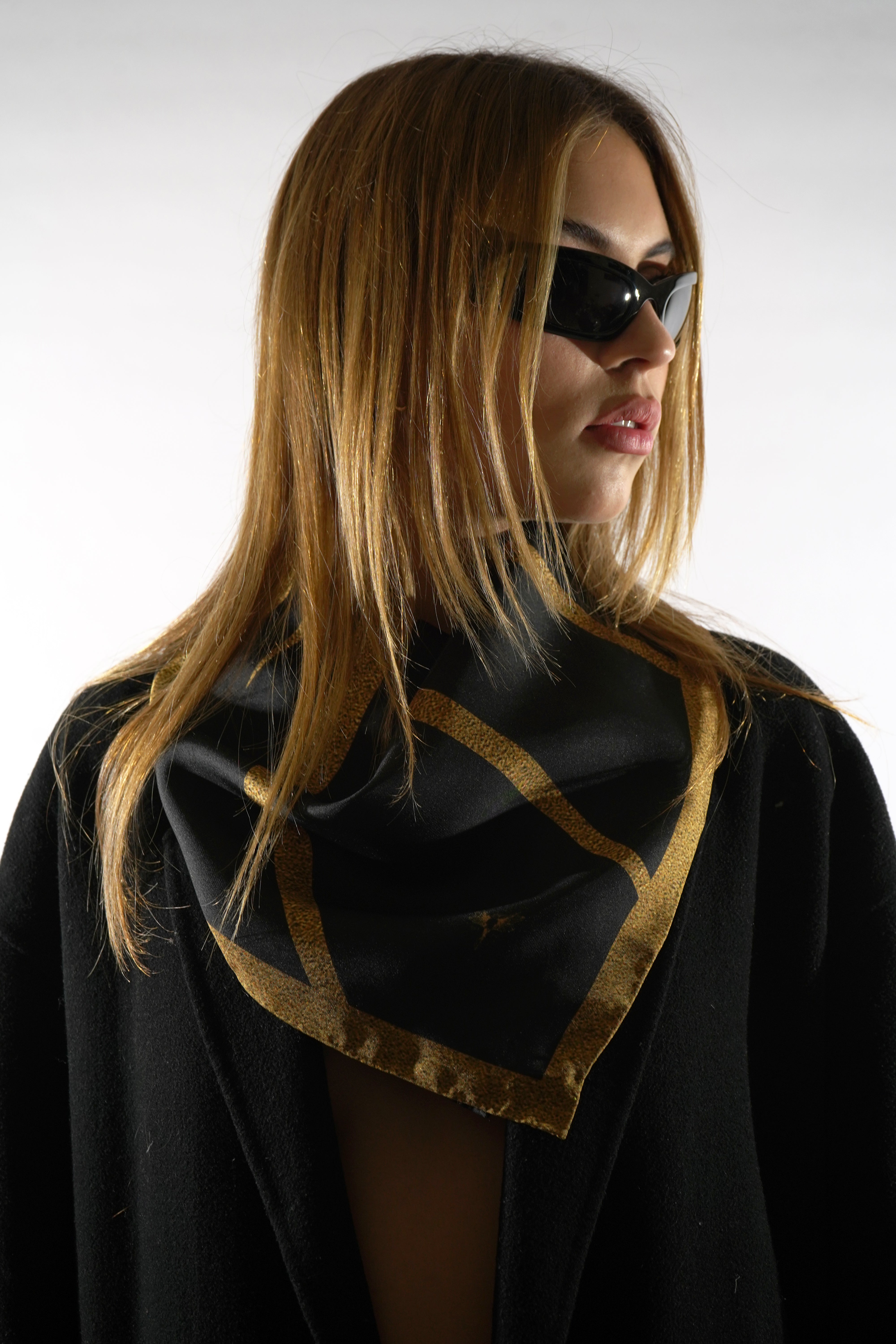 Model wearing black and gold silk twill square scarf around neck