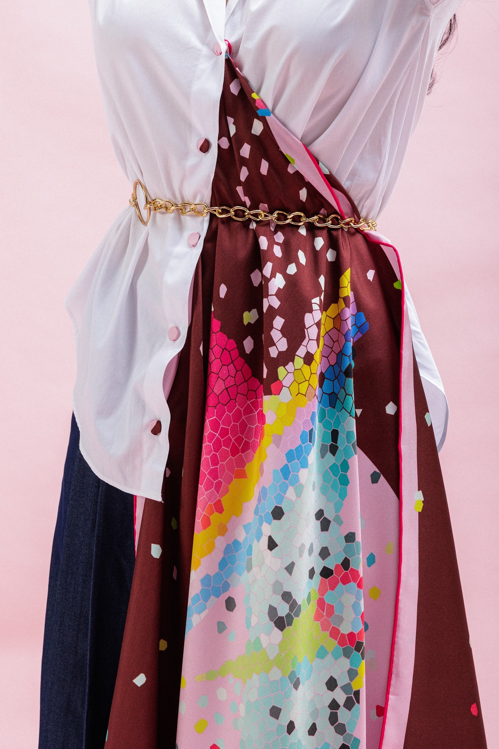 Colorful silk scarf styled on a shirt with a gold belt