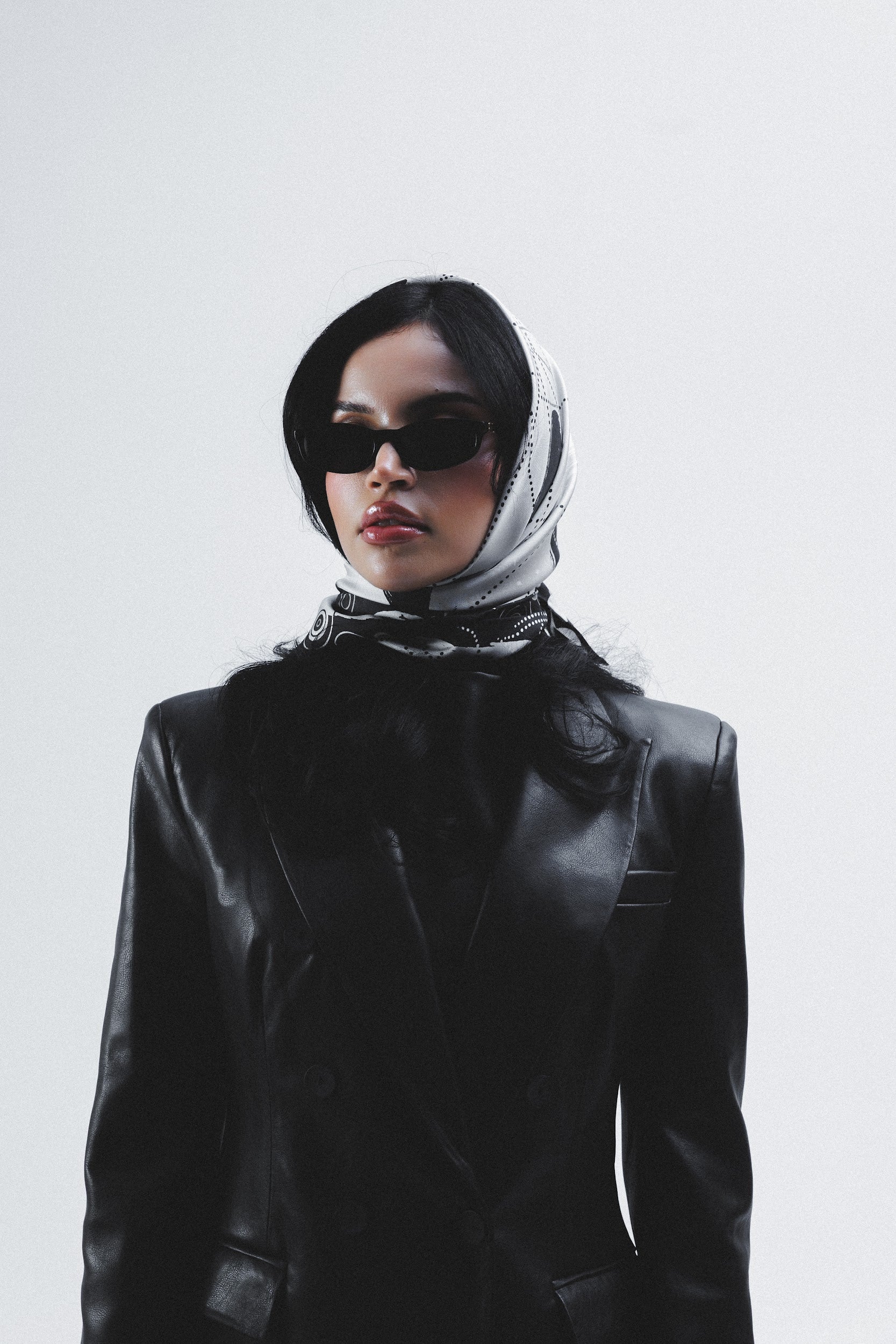 Model wearing black and white silk twill scarf on head 