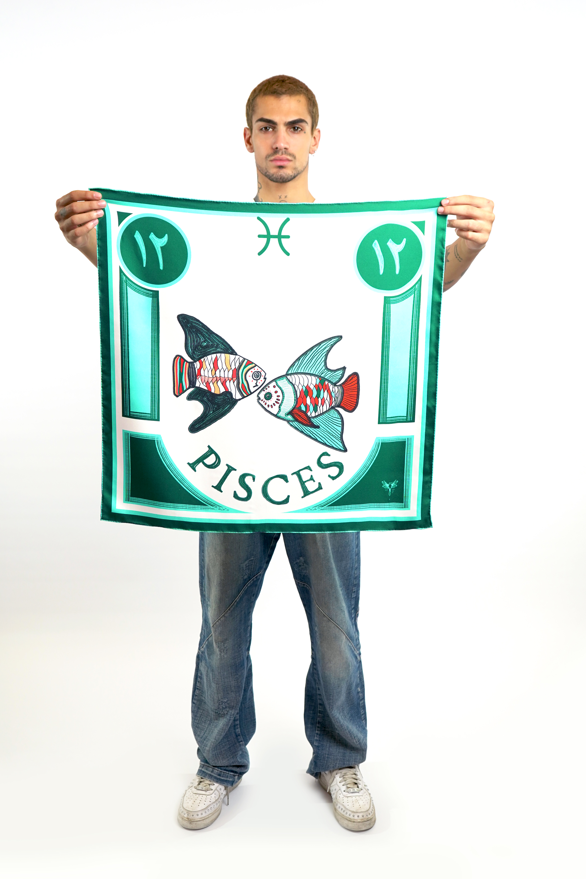 Male model holding silk twill square scarf with pisces design