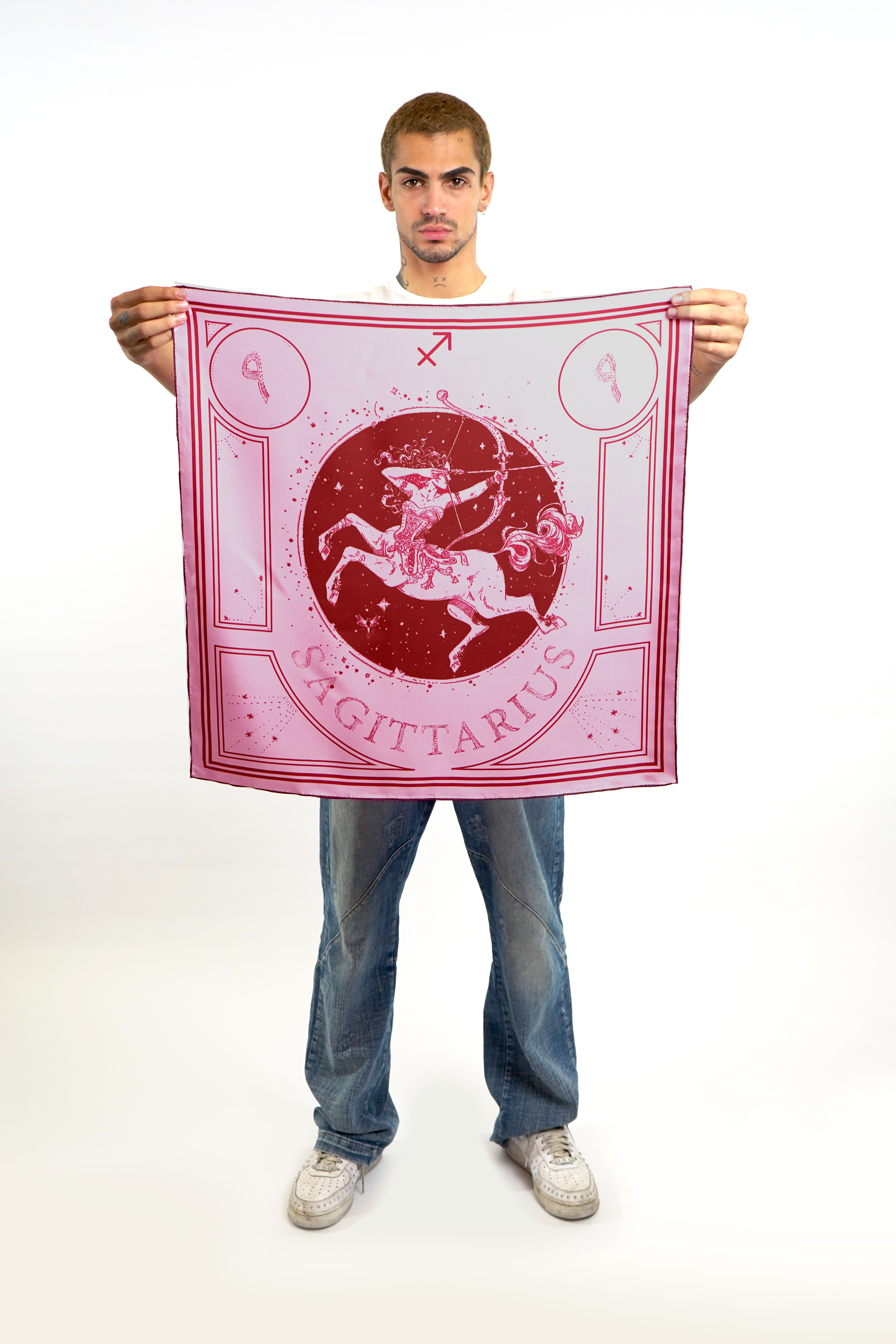 Male model holding silk twill square scarf with sagittarius astrology design 