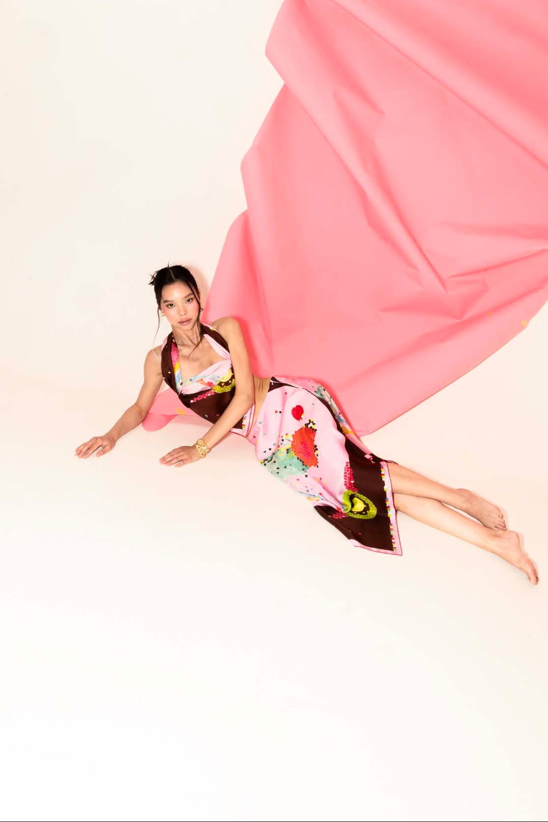 Woman wearing a colorful set with a silk skirt and matching scarf as top