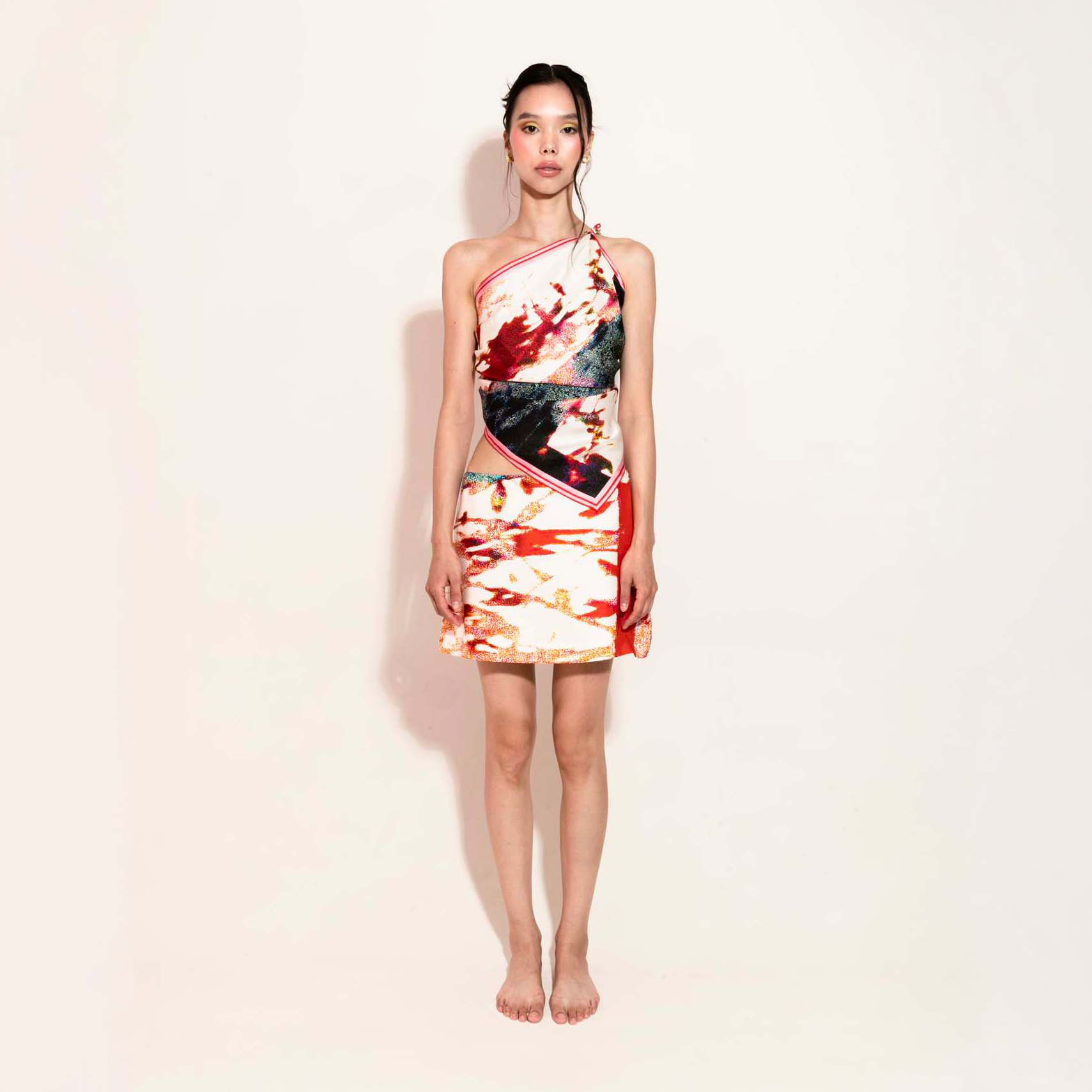 Model wearing a colorful set with a silk scarf as a top with the matching skirt 