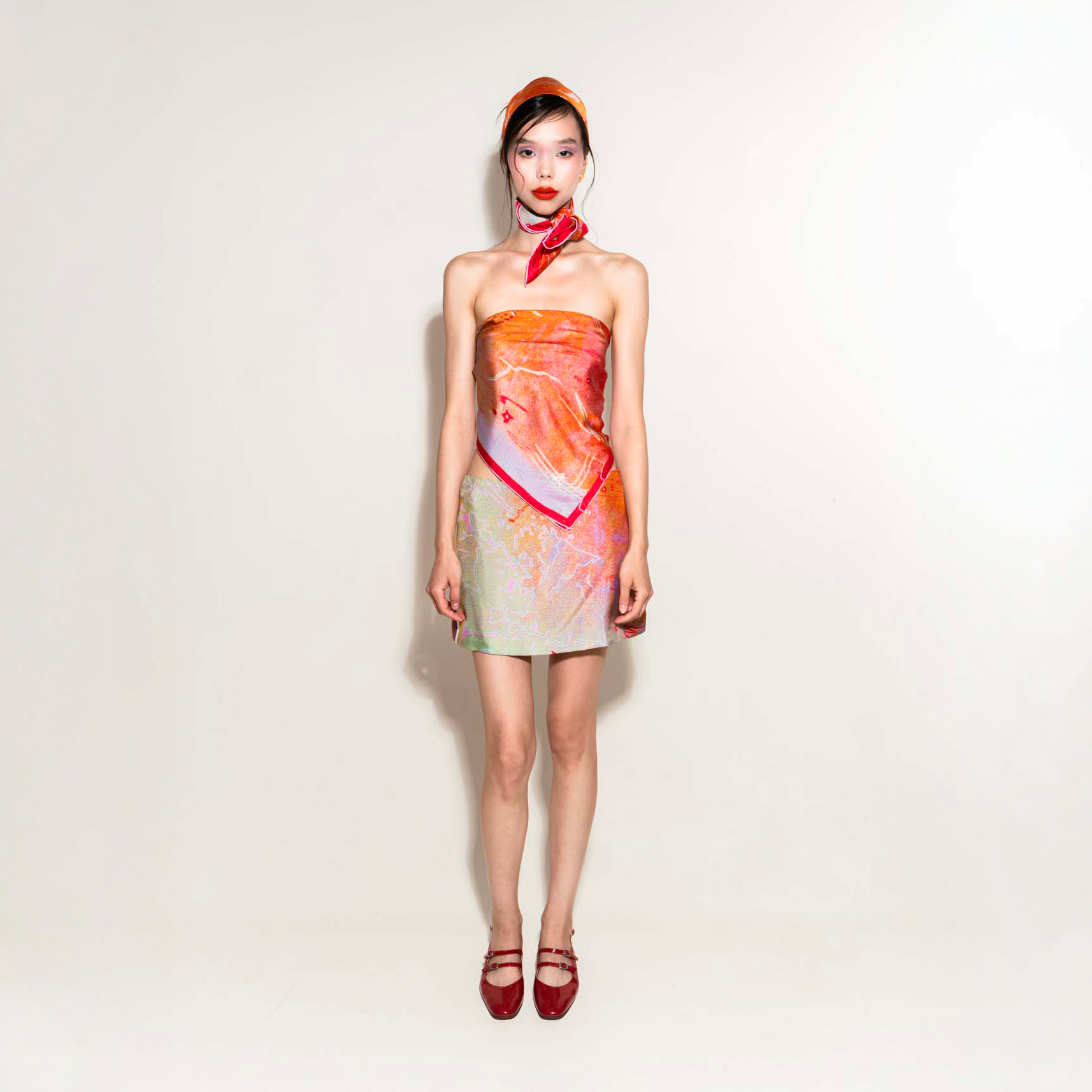 Model wearing a colorful orange pink green silk scarf and silk skirt 