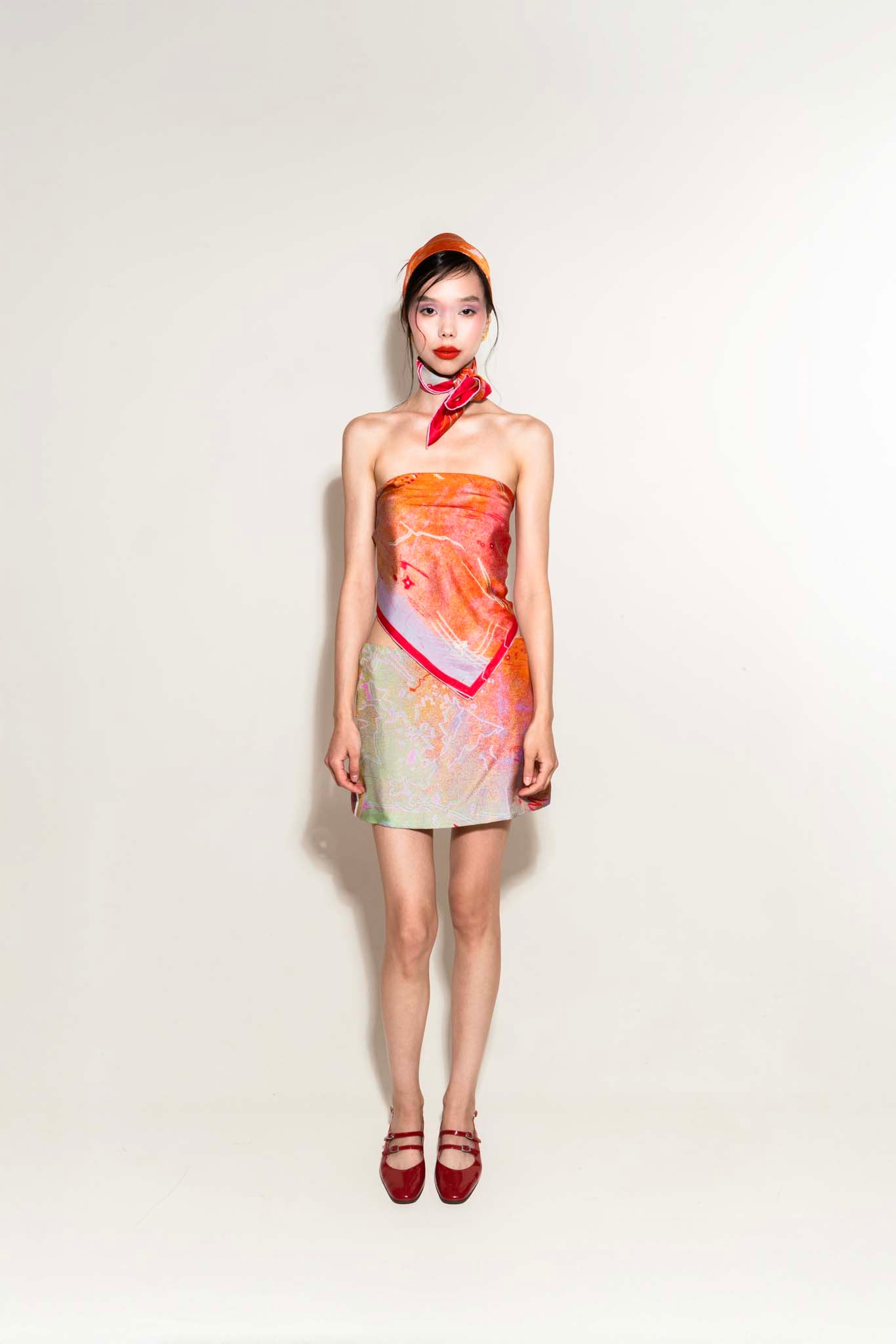 Model wearing a set with a silk scarf on her head, a silk scarf as a top and a silk skirt in matching patterns