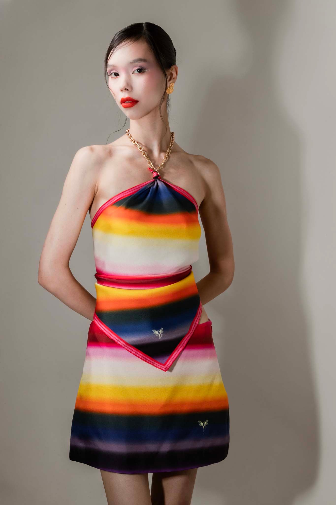 Model wearing a colorful striped silk square scarf and skirt