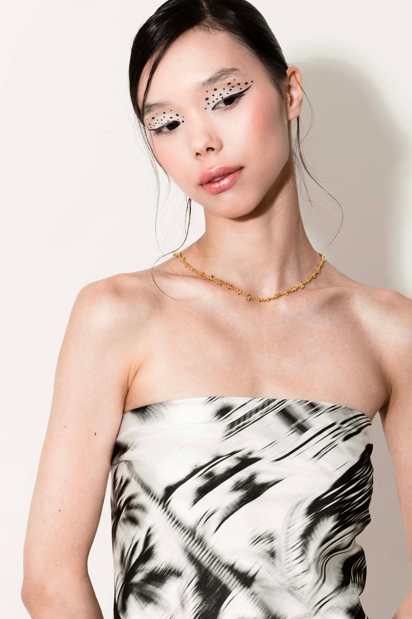 Woman wearing a black and white silk scarf with palm trees as a top