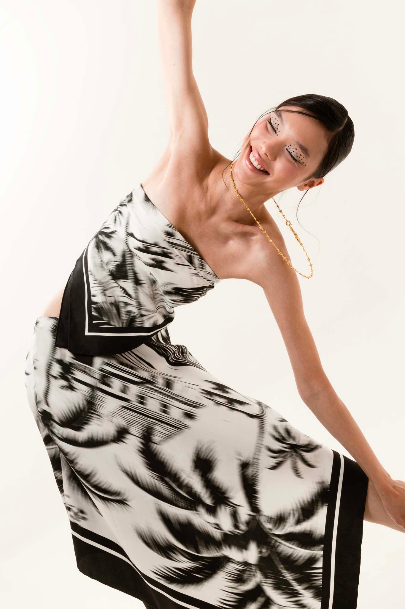 Woman wearing a black and white silk scarf as a top with matching asymmetrical skirt