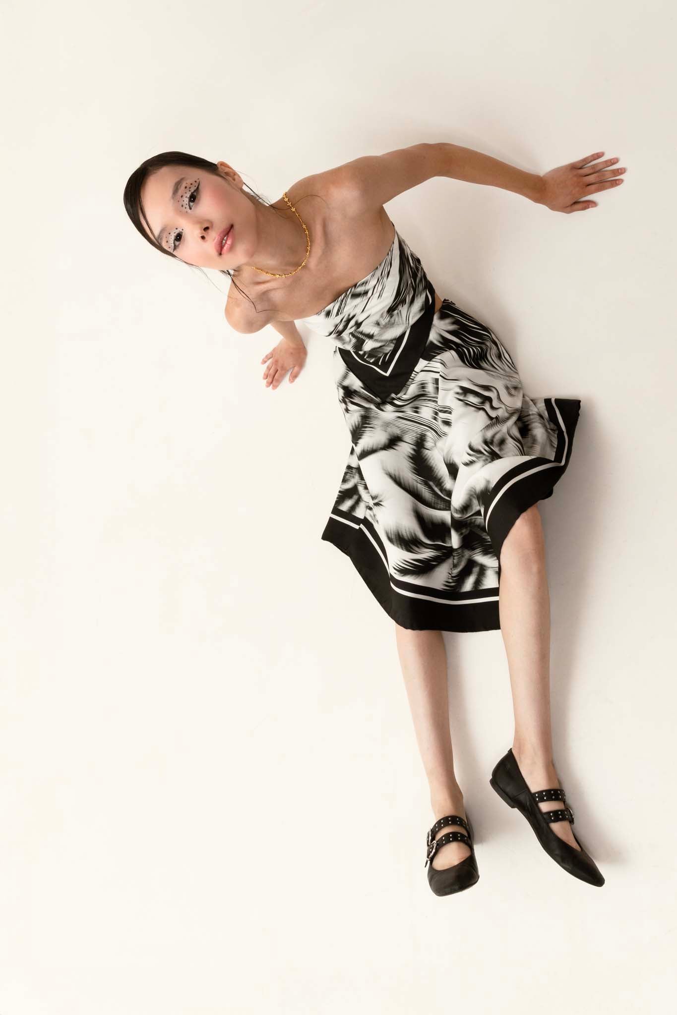 Woman wearing a black and white set with a silk scarf as top and asymmetrical skirt