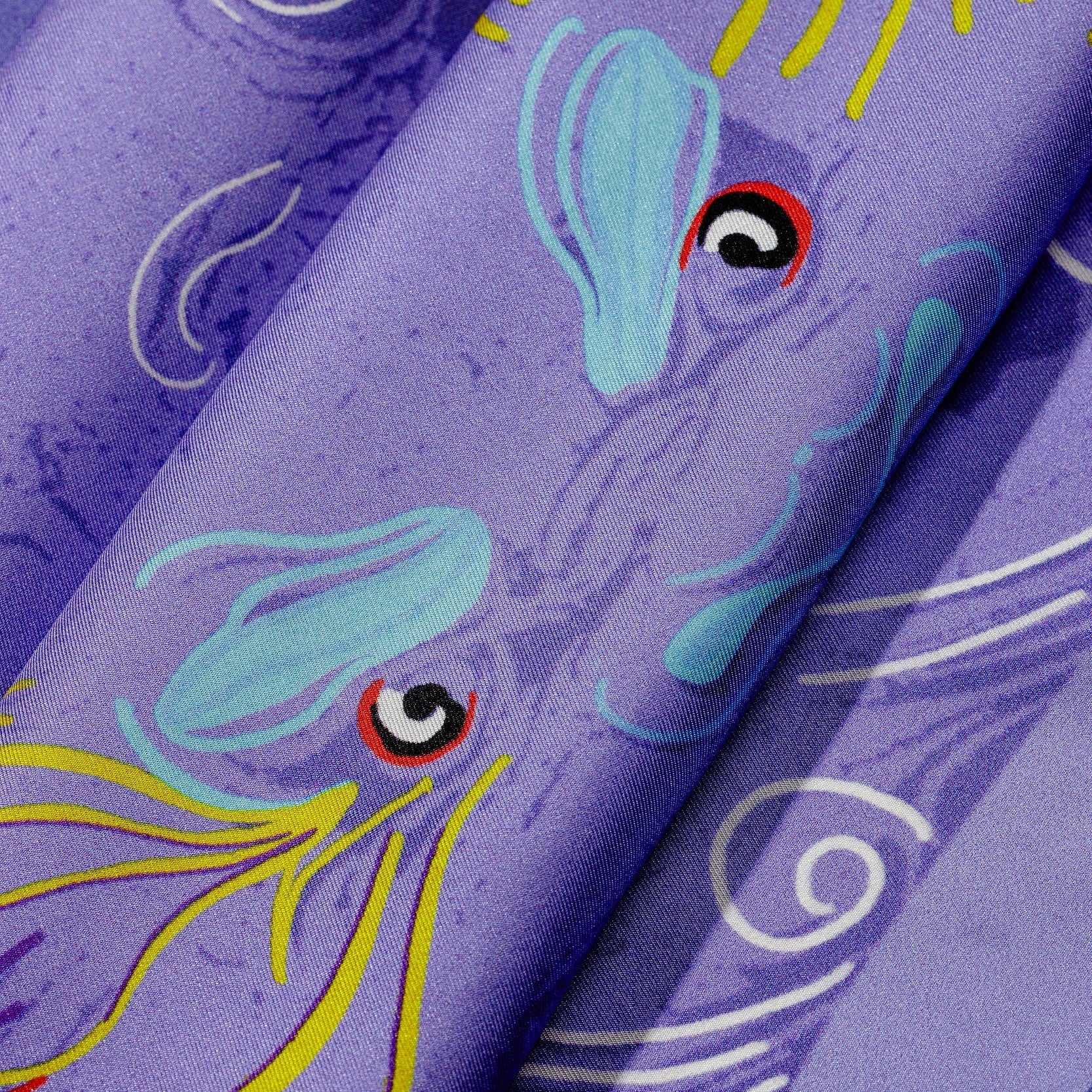 Close-up on silk twill fabric with purple dragon design