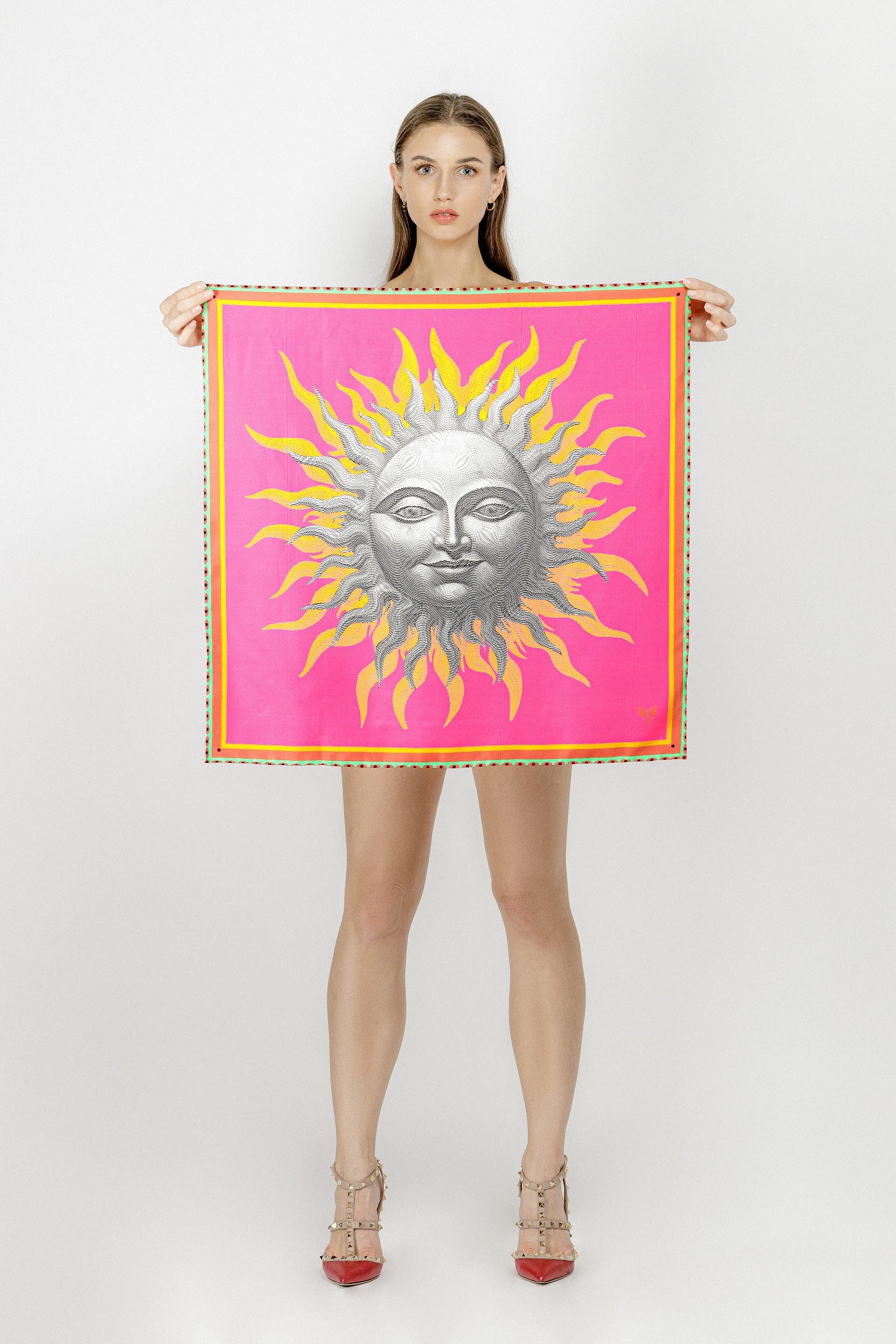 Model holding silk twill square scarf with sun print in bright colors