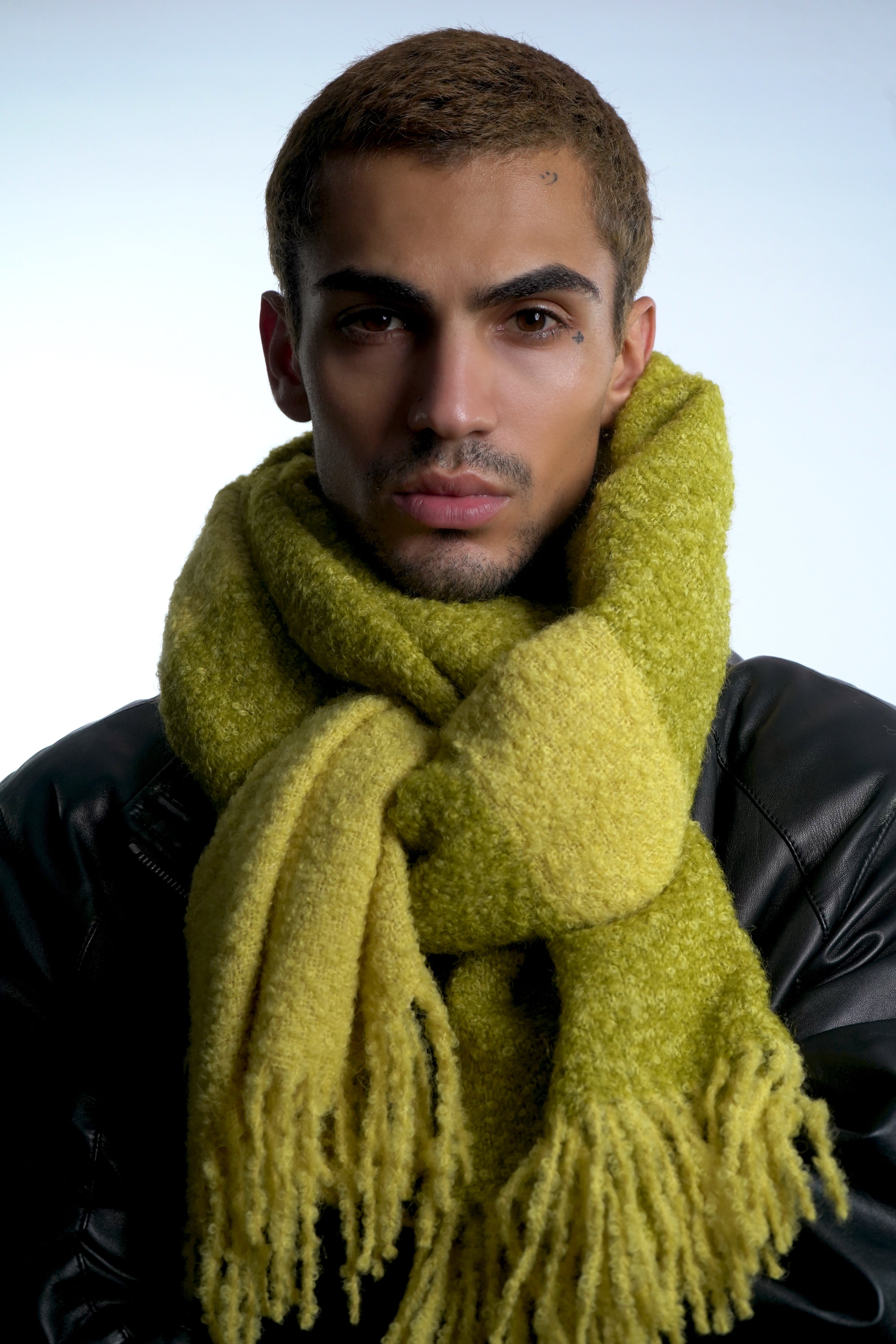 Male model wearing alpaca wool winter scarf around neck in green and yellow